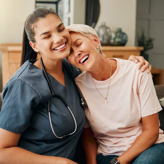 Senior woman, hug or medical caregiver in house living room in comfort trust, support or security bond. Smile, happy or laughing nursing home retirement elderly and healthcare Brazilian nurse or help